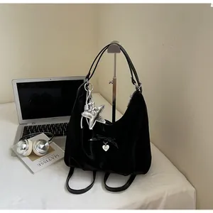 Detail of black satin hobo bag with ribbon, heart charm and silver star pendant