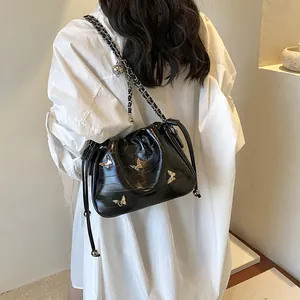 Sac seau noir minimaliste avec détail papillon argenté et bandoulière chaîne