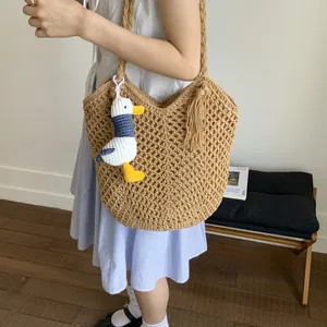 Large woven cotton rope beach tote with hollow pattern and plush charm pendant