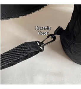 Dettaglio del gancio rotante in metallo nero opaco e della tracolla in nylon intrecciato