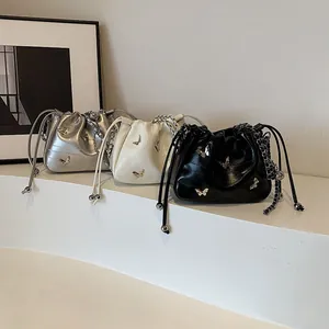 Trois sacs seaux à chaîne en argent, blanc et noir avec boucles papillon métalliques