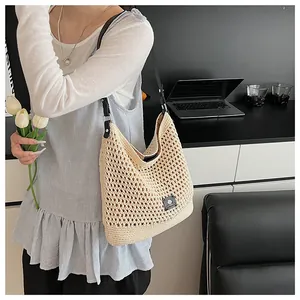 Detail of beige crochet tote bag with lazy breeze label and black leather shoulder strap
