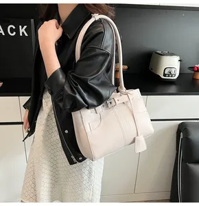 Dettaglio della borsa tote crema con cuciture vintage e cinturino con fibbia metallica