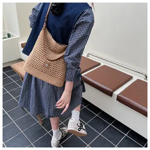 Detail of hand-woven hollow knit tote bag with premium brown leather strap for summer
