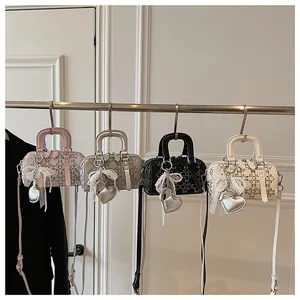 Detail of four denim Boston bags in pink silver black white with pearl heart charms