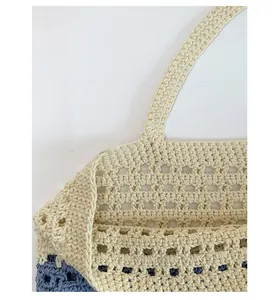 Detail of hand-crocheted hollow knit tote bag showing contrast stitching and texture