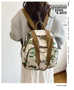 Detail view of large capacity backpack with green floral print and brown canvas straps
