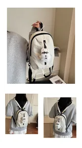 Dettaglio mini zaino in nylon bianco sporco con spallacci neri e ciondolo a forma di cane