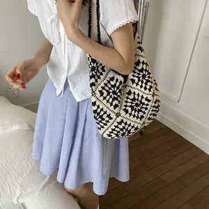 Handmade crochet tote bag with black and white floral pattern for casual summer use