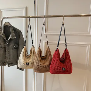 Handcrafted hollow knit tote bags in ivory, brown and red with leather handles and logo