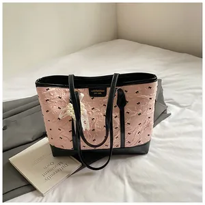 Detail der rosa Plissee-Tasche mit Schleifenmuster, Lederbesatz und Perlenanhänger