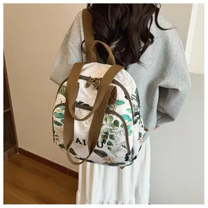 Detail of floral print backpack with AI U text, brown straps and dual zipper closure