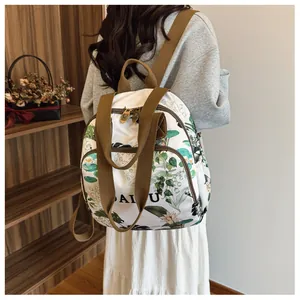 Detail view of large capacity backpack with green floral print and brown straps