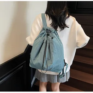 Détail d'un sac à dos en nylon bleu clair avec cordon de serrage et coutures renforcées