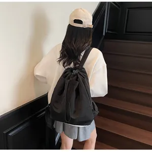 Vue de dos du mannequin portant un sac à dos noir à cordon au design minimaliste chic