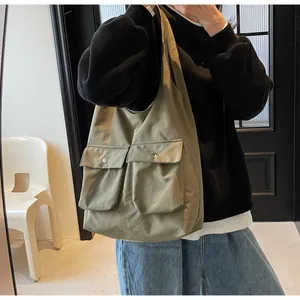 Detailaufnahme der olivgrünen Canvas-Einkaufstasche mit großen Taschen und Metallknöpfen