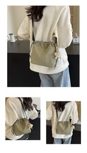 Détail du sac seau vert olive à cordon avec breloque monstre et bandoulière réglable