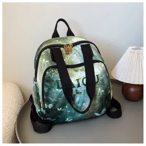 Detail of forest green mini backpack with butterfly print and gold zipper on a table