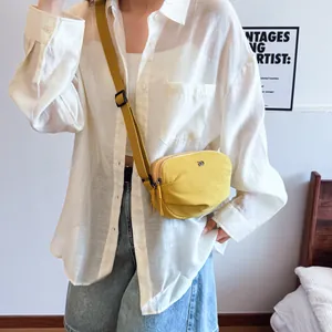 Lightweight yellow shell crossbody bag with adjustable strap and dual zipper closure