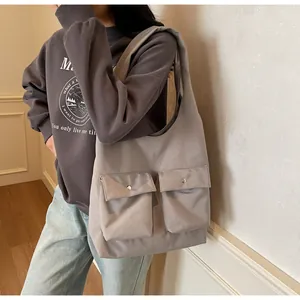 Detailansicht der grauen Canvas-Tragetasche mit zwei Vordertaschen und Magnetverschluss