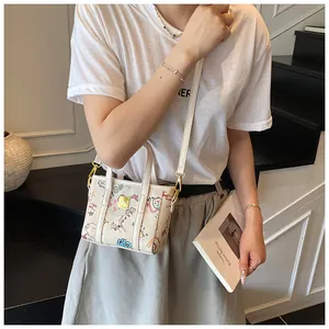 Detailaufnahme der Mini-Graffiti-Tasche mit bunter Street Art und goldener Hardware