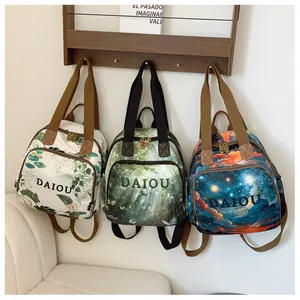Detailed view of three mini backpacks with floral, forest, and starry art prints