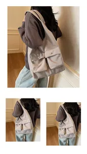 Detail der grauen Tragetasche mit zwei Vordertaschen und breitem Schultergurt-Design