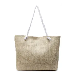 Natural straw tote bag with white rope handles for beach vacations and casual travel