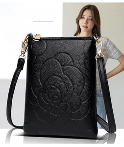 Detailed view of black floral embossed crossbody bag with gold hardware and lychee texture