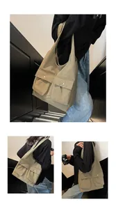 Detail der khakigrünen Canvas-Tragetasche mit funktionellen Doppeltaschen und Metalldruckknöpfen