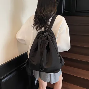 Sac à dos seau noir minimaliste à cordon avec poche frontale pour usage décontracté