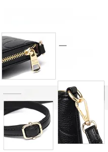 Detail of lychee textured leather and polished gold kangaroo logo zipper hardware