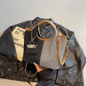 Chic patchwork denim bucket bag with brown leather handles and stylish silver chain detail