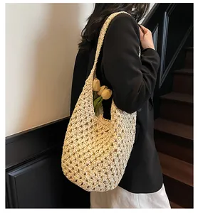 Close-up of beige paper rope hollow woven shoulder bag with large capacity for beach trips