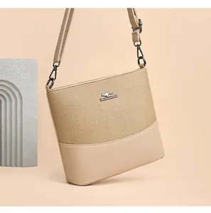 Detail of canvas and leather patchwork bucket bag with adjustable strap and metal logo