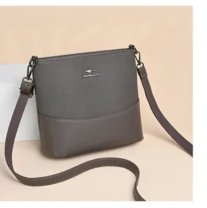 Detailed view of grey canvas and leather bucket bag with metallic kangaroo emblem