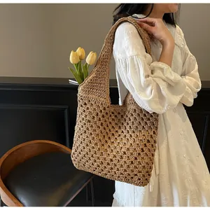 Detail of hand-woven straw tote bag with honeycomb mesh texture and integrated shoulder strap