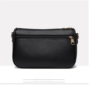 Detail view of the black lychee pattern leather handbag back with two golden zippers