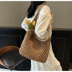 Detailed view of woven straw tote bag texture and wide strap on a model shoulder