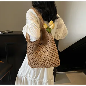 Close-up of woven straw tote bag featuring intricate hollow crochet texture and fabric lining