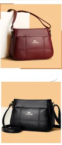 Detail of embroidered litchi grain leather bag with golden kangaroo logo and zip pocket