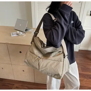 Detail of khaki nylon crossbody bag with large capacity and double front zippers