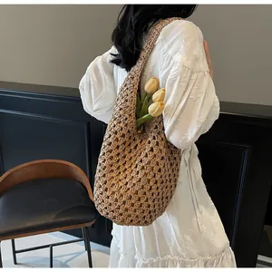 Close-up of a hollow woven straw shoulder bag featuring a rustic brown paper rope texture