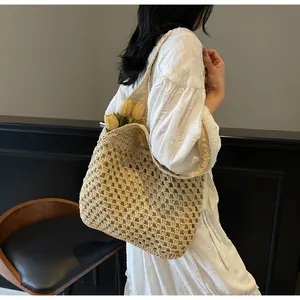 Detail of hand-woven beige tote bag with hollow mesh design and soft shoulder strap