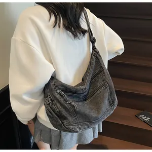 Detail of grey washed denim hobo bag featuring multi-pocket design and large capacity