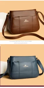 Detail of stitched leather texture with golden kangaroo logo on brown and blue handbags
