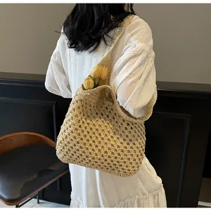 Detail of beige woven straw tote bag with intricate hollow mesh texture on a model