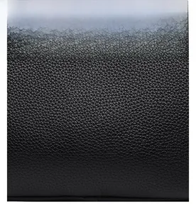 Close-up of premium black lychee-textured leather material with a soft glossy finish