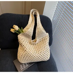Detailed close-up of a beige hollow crochet tote bag with inner lining on a chair