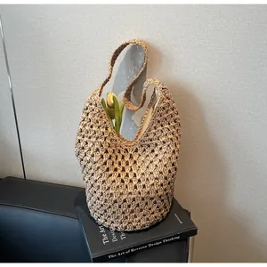 Detail of hollow woven paper straw tote bag featuring fabric lining and zipper closure